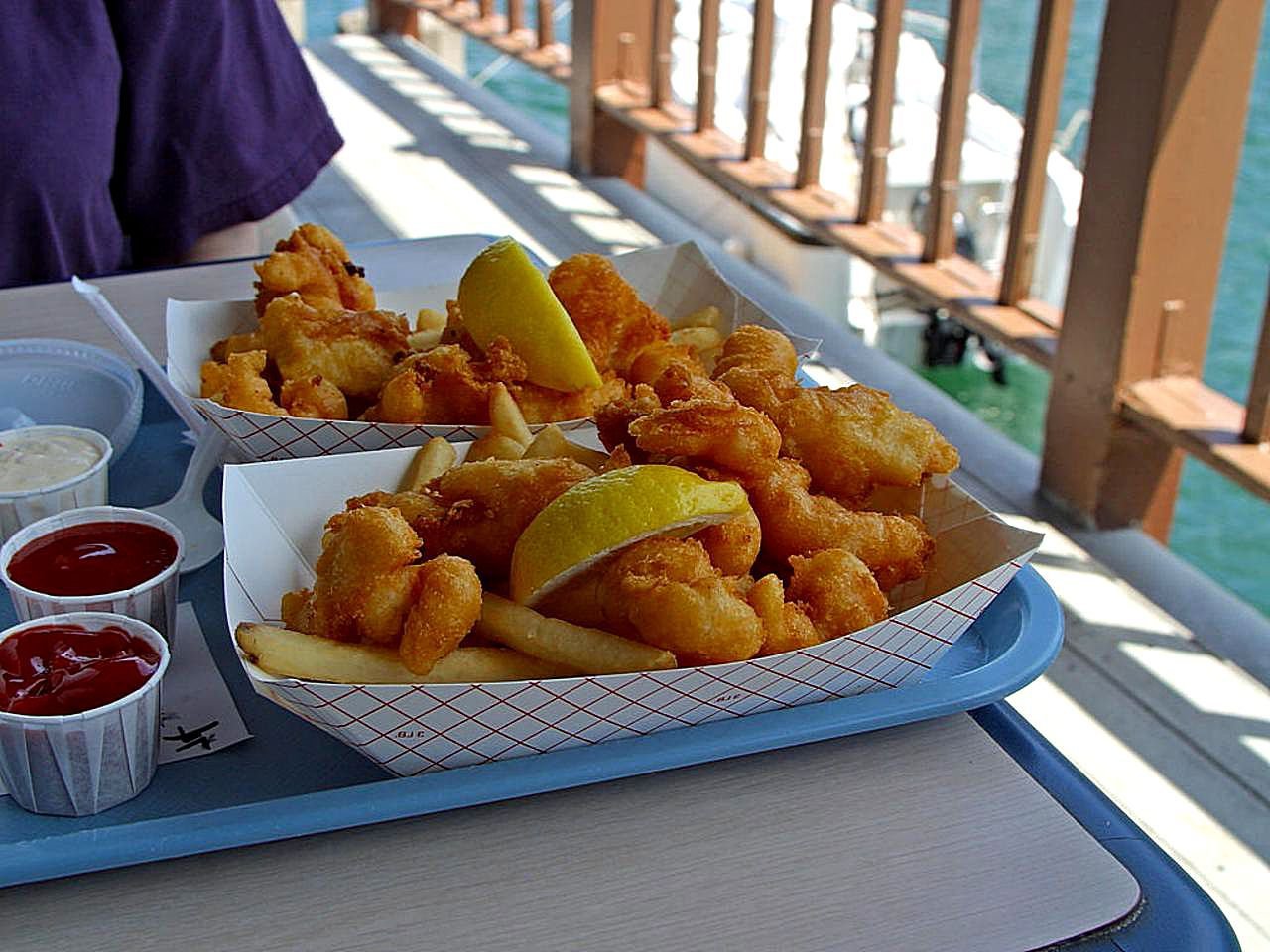 Platter of crispy golden fried Black Sea sprat with lemon wedges and cold Bulgarian beer