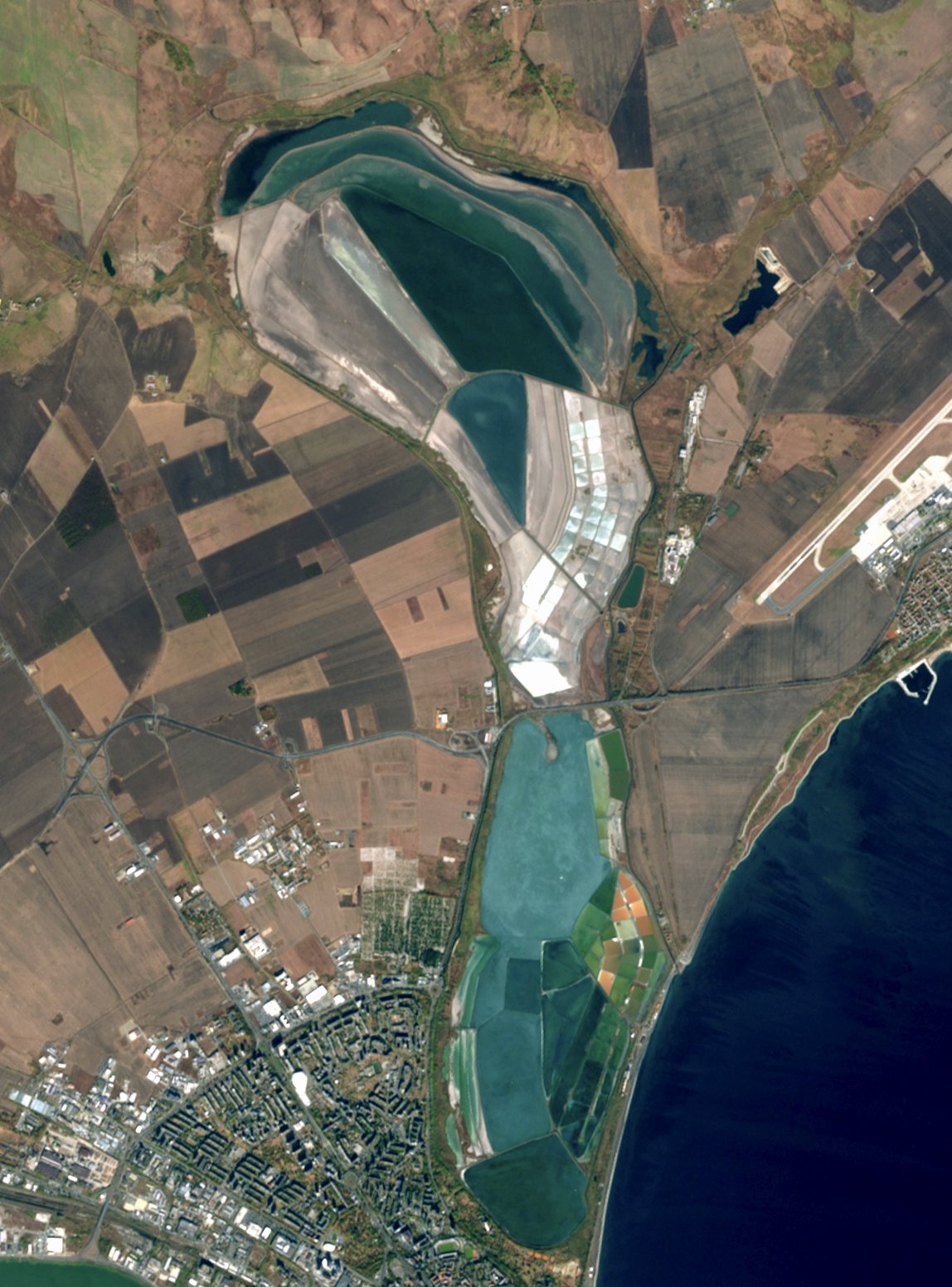 Traveler covered in therapeutic black peloid mud relaxing by the Black Sea